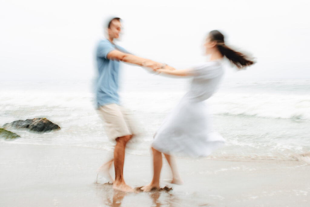 Couple spinning around with motion blur on the beach
